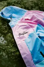 pink and purple windbreaker laying on rock