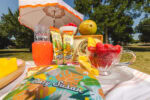 Mango Tea wraps on a table with fruit and and umbrella in the background