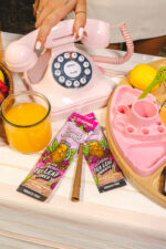 Raspberry Tea Wraps on a table next to a pink phone and Blazy Susan spinning tray.